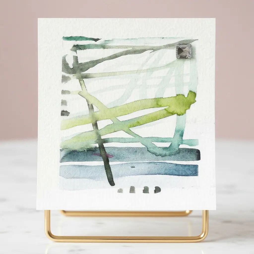 Abstract mini watercolor blue green watercolor painting with green and blue brush strokes on a white background, displayed on a gold stand.